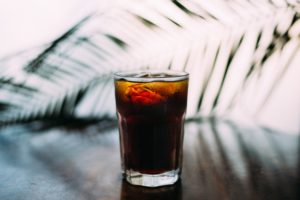 Glass of Soda sitting on a counter with palm frond
